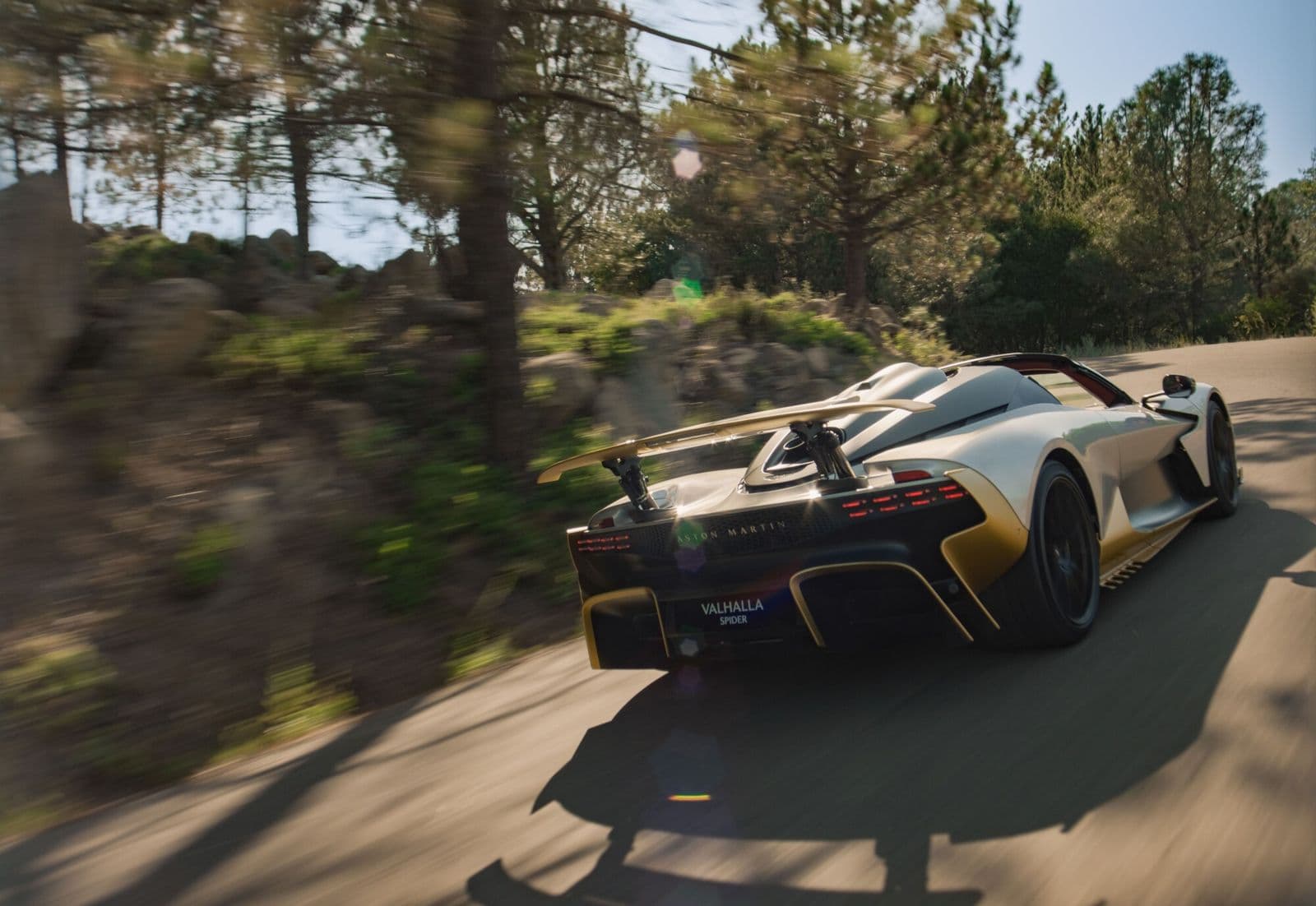 aston martin valhalla spider rear view with wing on a forest road